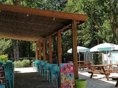 a group of chairs and tables and umbrellas at Bungalow toilé avec terrasse jusqu'à 5 personnes - API-1-52-1480 in Axat