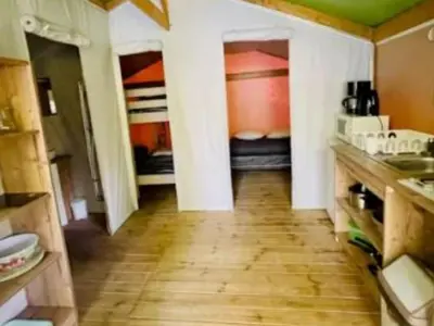 a kitchen with a hallway with two beds and a wooden floor at Lodge 22m² avec Terrasse - Pour 5 Personnes - API-1-52-1500 in Camon