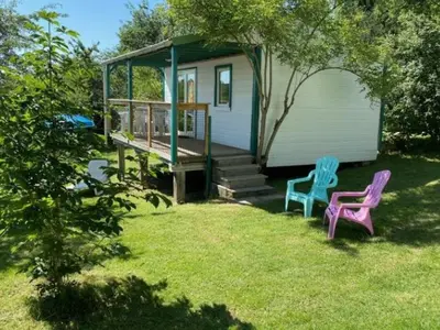 two chairs sitting in the grass in front of a house at Lodge 22m² avec Terrasse - Pour 5 Personnes - API-1-52-1500 in Camon