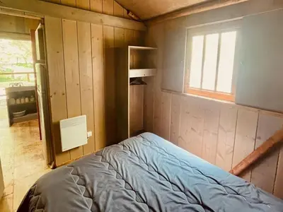 a small bedroom with a bed and a window at Cabane sur pilotis avec terrasse au calme - API-1-52-1502 in Camon