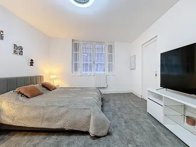 a bedroom with a bed and a flat screen tv at Le Flatters - studio en hyper centre - Proche des Halles in Narbonne