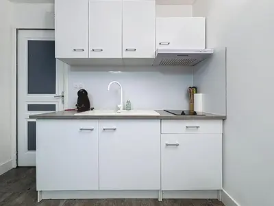 a kitchen with white cabinets and a sink at Le Flatters - studio en hyper centre - Proche des Halles in Narbonne