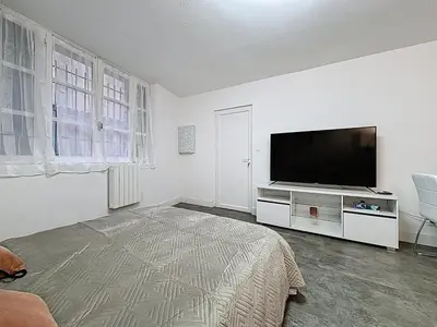 a living room with a flat screen tv on a white wall at Le Flatters - studio en hyper centre - Proche des Halles in Narbonne