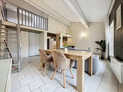 a large kitchen with a wooden table and chairs at Le Vicomte - Appartement en Duplex - Centre ville in Narbonne