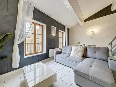 a living room with a couch and a window at Le Vicomte - Appartement en Duplex - Centre ville in Narbonne