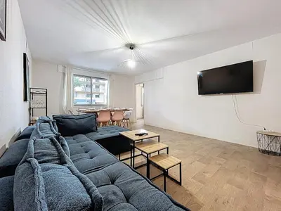 a living room with a couch and a flat screen tv at Le Carnot - Spacieux appartement pour 8 personnes - Proche Gare in Narbonne