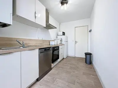a white kitchen with a sink and a refrigerator at Le Carnot - Spacieux appartement pour 8 personnes - Proche Gare in Narbonne