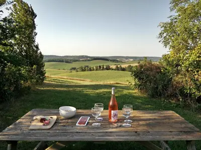 a wooden table with a bottle of wine and glasses at Holiday Home Gemütliches Ferienhaus in Villautou by Interhome in Villautou
