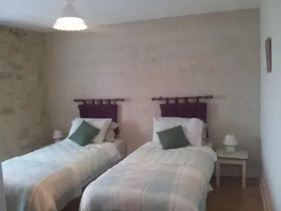 a bedroom with two beds and a table with a lamp at Holiday Home Haus für 6 Personen und 8 Kinder in Villautou by Interhome in Villautou