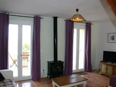 a living room with purple curtains and a wood stove at Holiday Home Schönes Ferienhaus mit Pool in Villautou by Interhome in Villautou