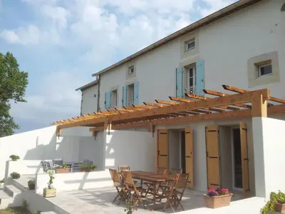 an external view of a house with a wooden table and chairs at Holiday Home Schönes Ferienhaus mit Pool in Villautou by Interhome in Villautou
