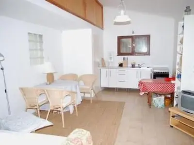 a living room with a table and chairs and a kitchen at Apartment Die kleine Zikade by Interhome in Cesseras