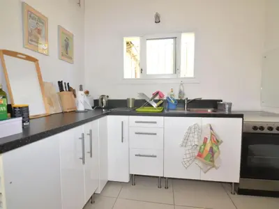 a kitchen with white cabinets and a sink at Apartment Die kleine Zikade by Interhome in Cesseras