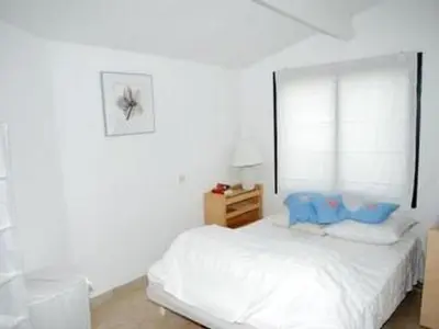 a white bedroom with a bed and a window at Apartment Die kleine Zikade by Interhome in Cesseras