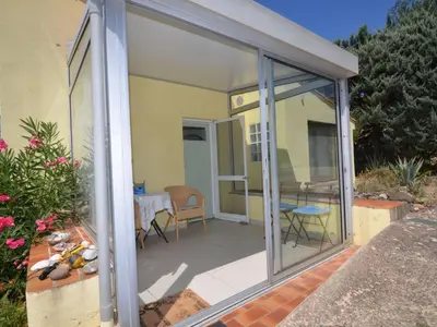 a conservatory with sliding glass doors on a patio at Apartment Die kleine Zikade by Interhome in Cesseras
