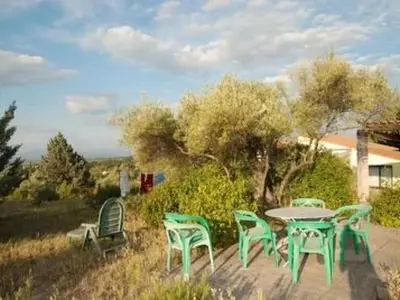 a table and chairs in a yard with a tree at Apartment Die kleine Zikade by Interhome in Cesseras