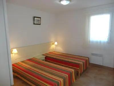 a bedroom with a bed with a striped blanket at Holiday Home VILLA T3 PMR ZWISCHEN NARBONNE UND CARCASSONNE by Interhome in Homps