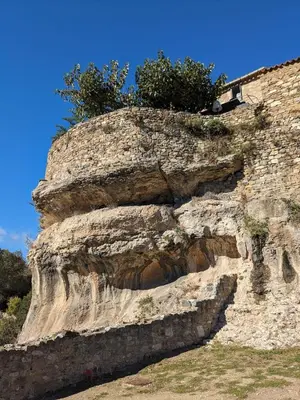 a rock cliff with plants on top of it at La Pepiniere a beautiful air-con villa with private pool In the canal-side village of Homps in Homps