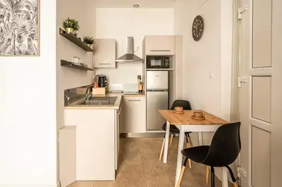 a small kitchen with a wooden table and chairs at Studio narbonne in Narbonne