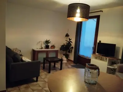 a living room with a couch and a table at Cheminée, jardin et tranquillité assurée in Verdalle