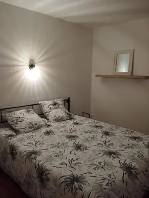 a bedroom with a bed with a blanket with plants on it at Cheminée, jardin et tranquillité assurée in Verdalle