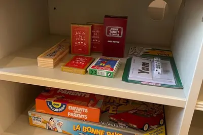 a shelf filled with books and other games at Gîte Le Courredou Portel des Corbières in Portel-des-Corbières
