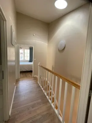 a hallway of a home with a staircase and a bed at Gîte Le Courredou Portel des Corbières in Portel-des-Corbières