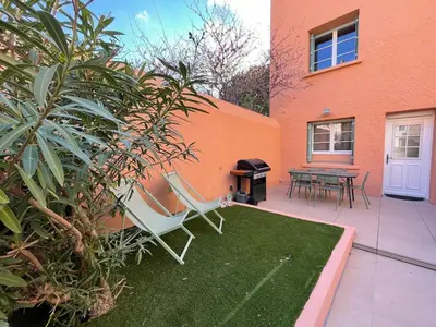 a patio with a chair and a grill next to a building at Gîte Le Courredou Portel des Corbières in Portel-des-Corbières