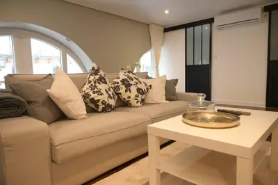 a living room with a couch and a table at La Chouette - Atypique & lumineux, Place Jean Jaurès in Castres