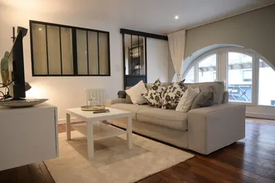 a living room with a couch and a table at La Chouette - Atypique & lumineux, Place Jean Jaurès in Castres