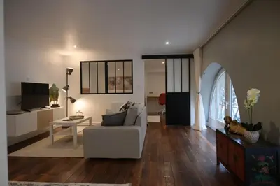 a living room with a white couch and a table at La Chouette - Atypique & lumineux, Place Jean Jaurès in Castres
