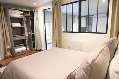 a bedroom with a white bed and a window at La Chouette - Atypique & lumineux, Place Jean Jaurès in Castres