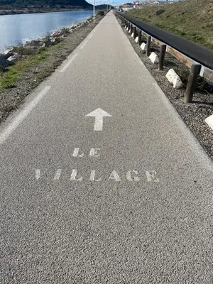 a road with an arrow painted on the road at Studio cosy avec piscine et parking à Gruissan in Gruissan