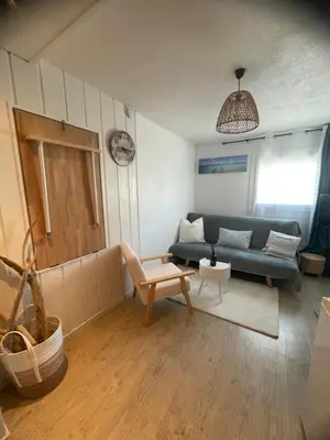 a living room with a blue couch and a table at Studio cosy avec piscine et parking à Gruissan in Gruissan