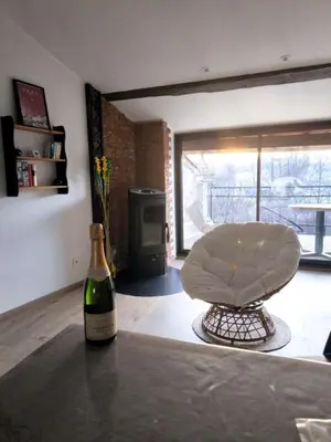 a bottle of wine sitting on a table next to a chair at La maison au bord de l'Aude in Limoux