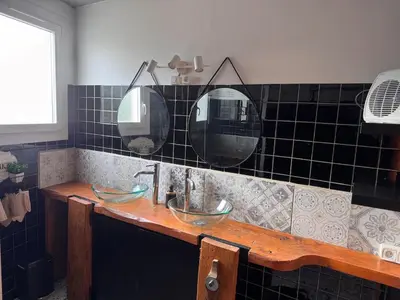 a bathroom with two sinks and two mirrors at La maison au bord de l'Aude in Limoux