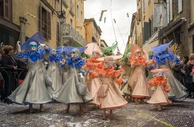 a group of people in costumes walking down a street at La maison au bord de l'Aude in Limoux