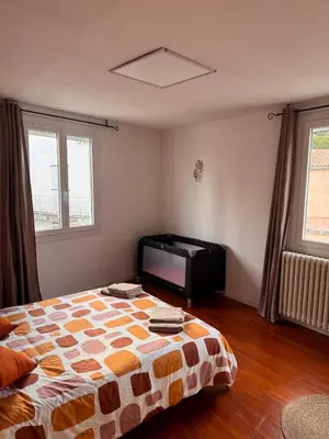 a bedroom with a bed and a television in it at La maison au bord de l'Aude in Limoux