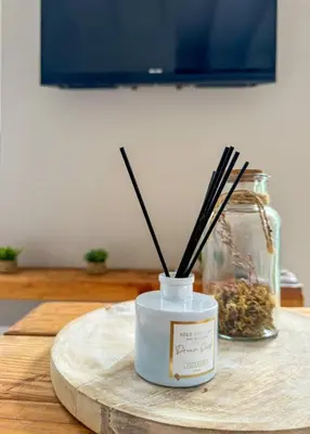 a candle on a wooden table with chop sticks in it at Le Havre de Paix in Espérausses