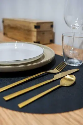 a table with gold chopsticks and a plate and a glass at L'Intime - Cozy & air-conditioned duplex - Near Carcassonne in Pennautier