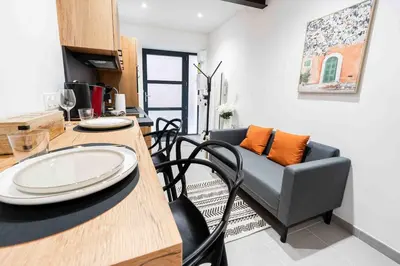 a living room with a table and a couch at L'Intime - Cozy & air-conditioned duplex - Near Carcassonne in Pennautier