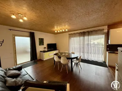 a living room with a table and chairs in a room at Les ferrajals in Rouvenac