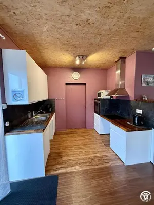 a kitchen with white counters and a red door at Les ferrajals in Rouvenac