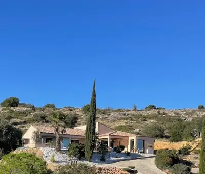 a house in the middle of a hill with trees at Villa piscine climatisation vue mer pour 8 in Fitou