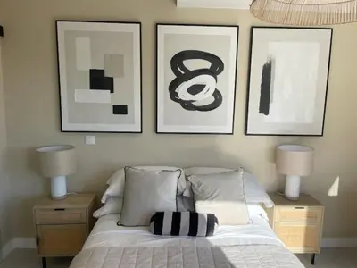 a bedroom with a bed with three pictures on the wall at Villa piscine climatisation vue mer pour 8 in Fitou