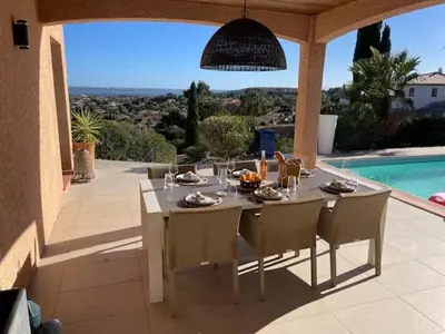 a dining table and chairs on a patio next to a pool at Villa piscine climatisation vue mer pour 8 in Fitou