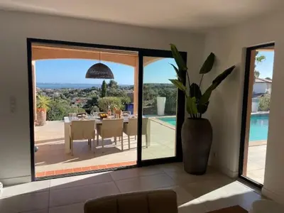a dining room with a table and a large glass window at Villa piscine climatisation vue mer pour 8 in Fitou