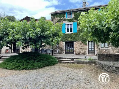 a stone house with a tree in front of it at Domaine de la calm in Villardonnel