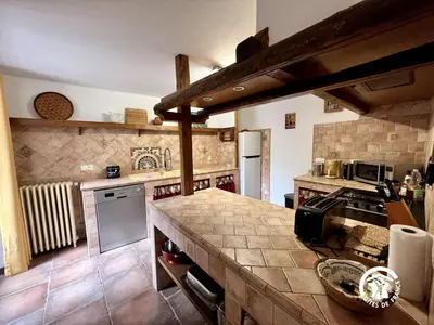 a large kitchen with a counter top in a room at Domaine de la calm in Villardonnel