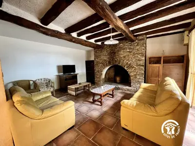 a living room with two couches and a stone fireplace at Domaine de la calm in Villardonnel